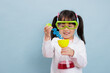 young  girl pretend play scientist role at home against plain background