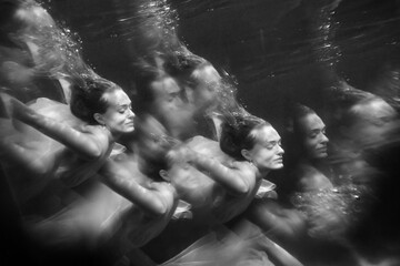 Wall Mural - Young beautifull caucasian woman in dress under water in black and white