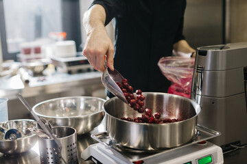 Close up. A chef weighs cherries for baking a fruit pie or other desserts.