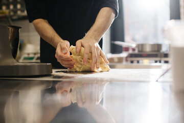 Wall Mural - Close up. The cook kneads the dough with his hands, making macaroons or cakes.