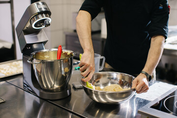 Wall Mural - The chef works in the kitchen. The process of making dough for macaroons.