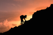 Man Climbing Up A Mountain Challenging Himself. Overcoming Difficulties, Life Obstacles, Problems, Struggle, Failure Concept. 