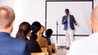 © JackF - Positive African American with microphone speaking at corporate business event in conference room
