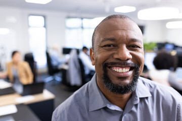 Wall Mural - Happy african american businessman looking at camera in office