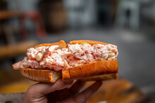 Maine Lobster Roll Sandwich In Brioche Bun Bread In Seafood Restaurant Cafe In Key West, Florida With Hand Holding Macro Closeup