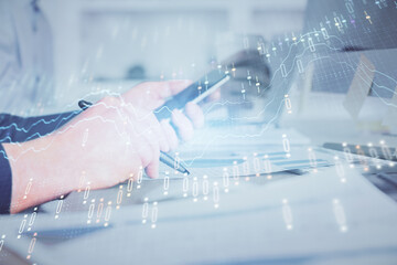 Poster - Double exposure of man's hands holding and using a phone and financial chart drawing. Market analysis concept.