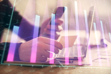 Poster - Double exposure of man's hands holding and using a phone and financial graph drawing. Analysis concept.