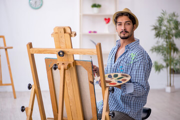 Canvas Print - Young man enjoying painting at the studio