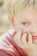 © Caseyjadew - Close up portrait image of serious young boy with chin resting on hand