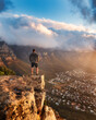 Young man standing on the top of the rock. Success, achieved goal concept, Photo taken in Cape Town, South Africa