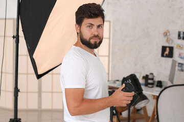 Poster - Handsome photographer with camera in studio