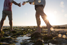 Low Angle View Of Couple Walking In Tidal Pools