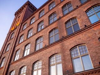 Old finnish industrial building made of bricks. This old spinning mill was built in 1890s, it has a tower and large arched windows.