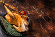 Roast guinea fowl with herbs and spices, cooked game bird. Dark background. Top view. Copy space