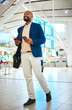Black man walking in airport with phone and ticket, checking flight schedule in terminal and holding passport for business trip. Smile, travel and happy businessman boarding international destination