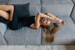 © F8  \ Suport Ukraine - Charming young woman in black dress on a couch at home