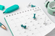 © thanksforbuying - Scheduling and planning concept, Calendar with pinned date and stationery on white desk