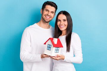 Sticker - Photo portrait of nice young guy girl holding little house marriage mortgage wear trendy white garment isolated on blue color background