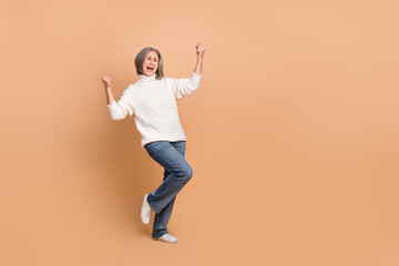 Sticker - Full body length photo of overjoyed funny pensioner woman fists up celebrating victory project finance manager isolated on beige color background