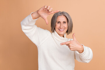 Poster - Photo of cheerful positive lady dressed white sweater showing arms photo shot isolated beige color background