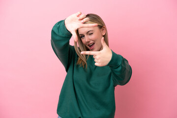 Wall Mural - Young caucasian woman isolated on pink background focusing face. Framing symbol