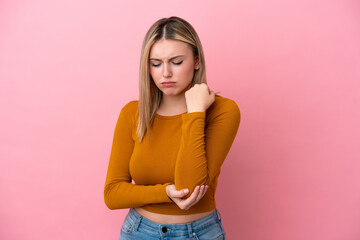 Wall Mural - Young caucasian woman isolated on pink background with pain in elbow