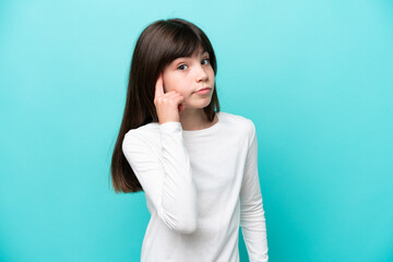 Wall Mural - Little caucasian girl isolated on blue background thinking an idea