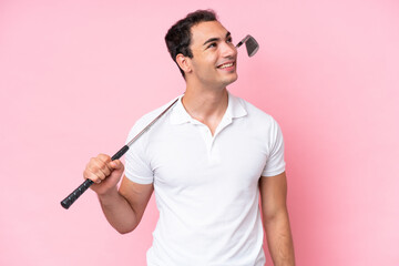 Wall Mural - Young golfer player man isolated on pink background thinking an idea while looking up