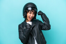Young Argentinian Woman With A Motorcycle Helmet Isolated On Blue Background Celebrating A Victory