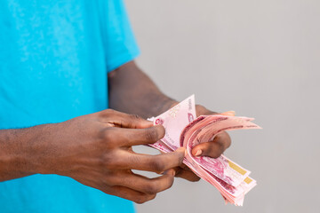 nigerian man counting money, new naira notes
