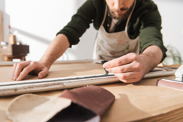 Wall Mural - Cropped view of craftsman restoring wooden picture frame in workshop.