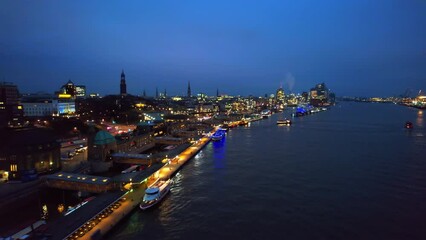 Wall Mural - Aerial drone view of Hamburg at evening, Germany. Elbe coastline, moored boats, sea port, classic and modern buildings, roads with cars and nightlights