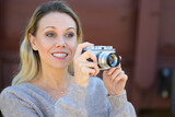 Fototapeta Paryż - Middle aged woman holding an old camera