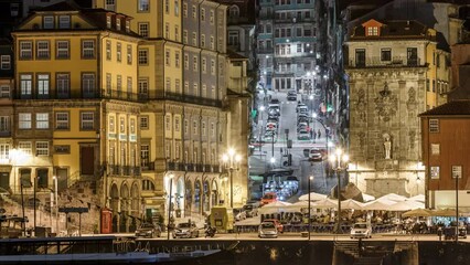 Wall Mural - Waterfront and traditional quaint houses in the old, vintage touristic ribeira district of Porto at night timelapse, Portugal. Illuminated street with cars and walking people