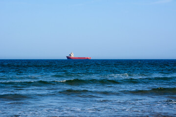 Sea view. Sea and sky panorama. Sea idyll. A lone freighter in the distance. Small sea waves