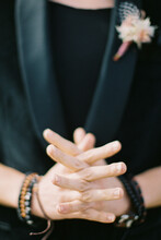 Crossed Fingers On The Hands Of A Man In A Black Jacket. Close-up