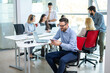 © Bojan - Handsome business using smart phone while taking a break in busy office.