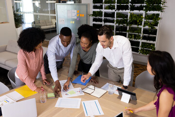 Diverse female and male businesspeople talking and working in office