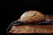 Rustic sourdough wheat bread on a wooden table and on a black background.