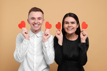 Wall Mural - Lovely couple with decorative hearts on beige background. Valentine's day celebration