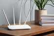 © New Africa - New white Wi-Fi router on wooden table indoors