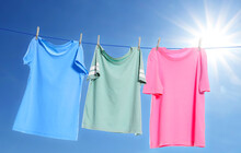 Different clothes drying on washing line against blue sky