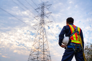 Wall Mural - A Technician or Worker holding a safety helmet wear fall arrestor device for worker with hooks for safety body harness. Working at height equipment. at high voltage electricity poles.