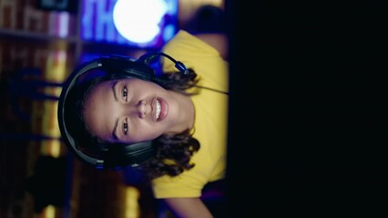 Poster - Young african american woman streamer playing video game using computer at gaming room