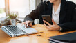 © Nuttapong punna - business documents on office desk with laptop and smart phone and graph business diagram and man working .
