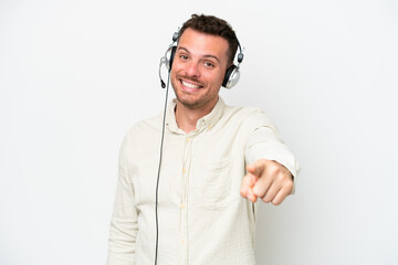 Wall Mural - Telemarketer caucasian man working with a headset isolated on white background points finger at you with a confident expression