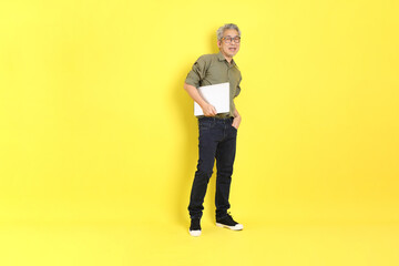 Wall Mural - The 40s adult Asian man with casual dressed standing on the yellow background.