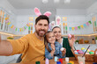 © New Africa - Happy family making selfie while painting Easter eggs in kitchen