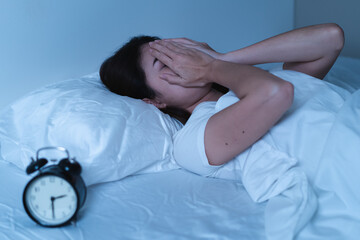 Wall Mural - Close-up alarm Young Asian woman have insomnia on the bed