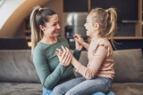 Fototapeta Przestrzenne - Happy mother and daughter enjoy spending time together at their home.